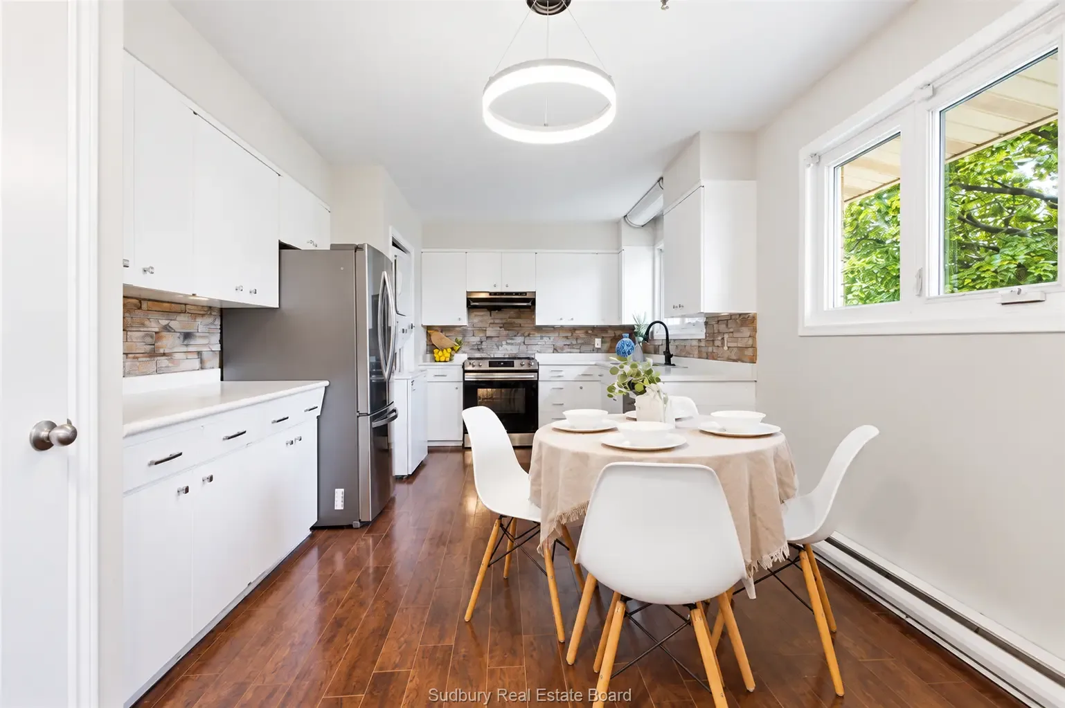 Main-floor apartment: eat-in kitchen with dining area and white cabinets